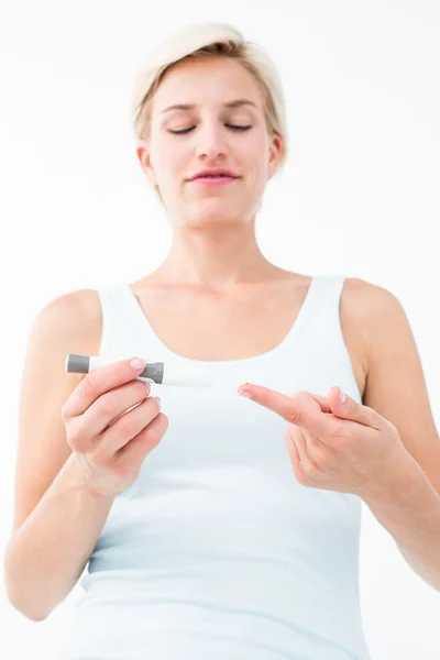Smiling woman testing her blood glucose level — Stock Photo, Image
