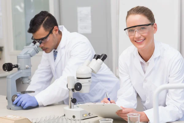 Scientists using microscope — Stock Photo, Image