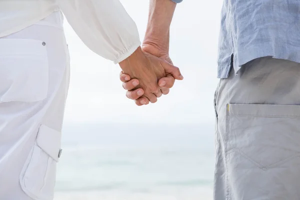 Paar hält Händchen am Strand — Stockfoto