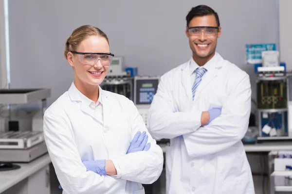 Scienziati sorridenti che guardano le braccia incrociate della fotocamera — Foto Stock