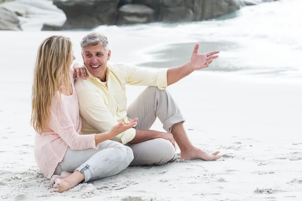 Feliz casal sentado na areia — Fotografia de Stock