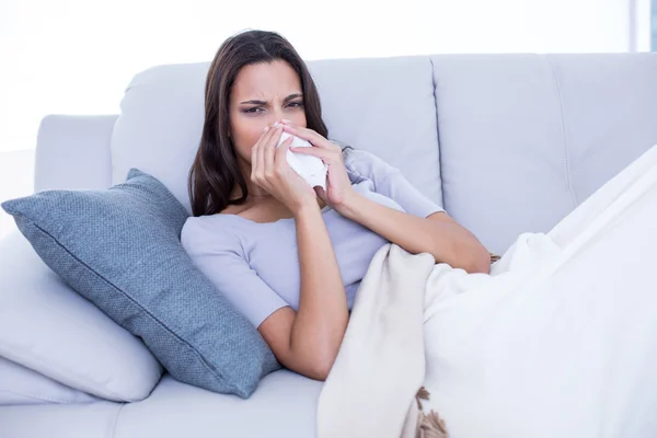 Malade brune couchée sur le canapé et se mouchant — Photo