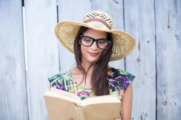 Sorrindo bela morena lendo um livro — Fotografia de Stock