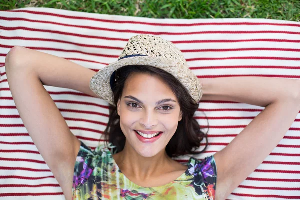 Smiling beautiful brunette lying on the blanket — Stock Photo, Image