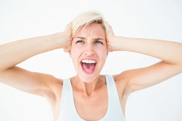 Angry blonde screaming and holding her head — Stock Photo, Image
