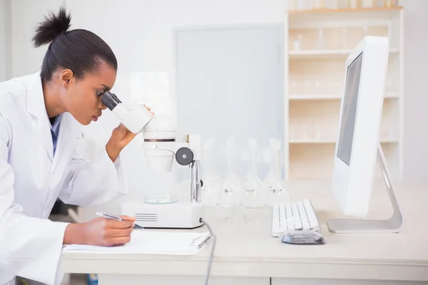 Científico concentrado mirando en el microscopio — Foto de Stock