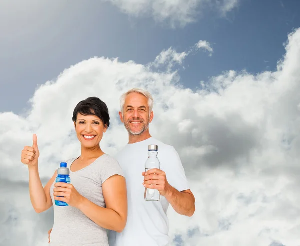 Paar mit Wasserflaschen gestikuliert mit dem Daumen — Stockfoto