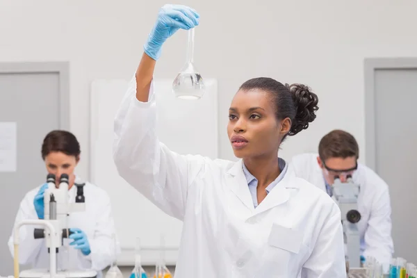 Scientist looking at white precipitate — Stock Photo, Image