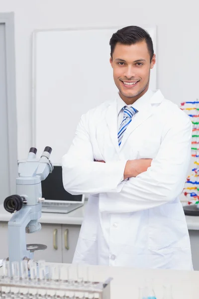 Scienziato sorridente alla macchina fotografica con le braccia incrociate — Foto Stock