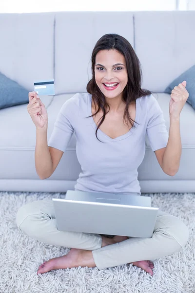 Sonriendo hermosa morena sentada en el suelo y haciendo en línea — Foto de Stock