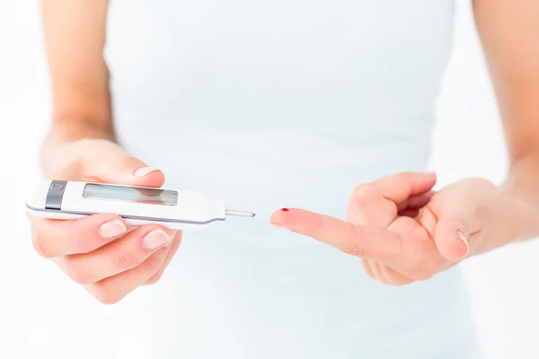 Woman testing her blood glucose level — Stock Photo, Image