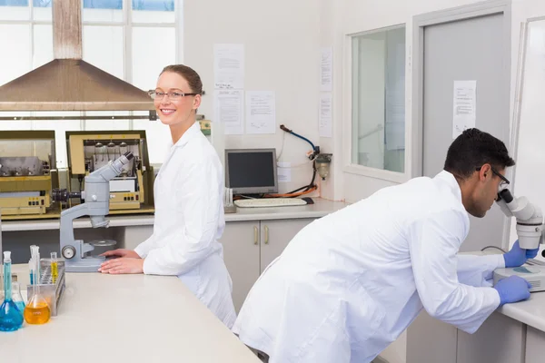 Científicos usando microscopio — Foto de Stock