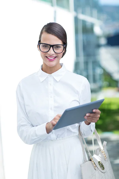 Pretty woman using her tablet pc looking at camera — Stock Photo, Image