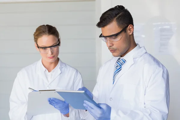 Wissenschaftler machen sich Notizen im Labor — Stockfoto