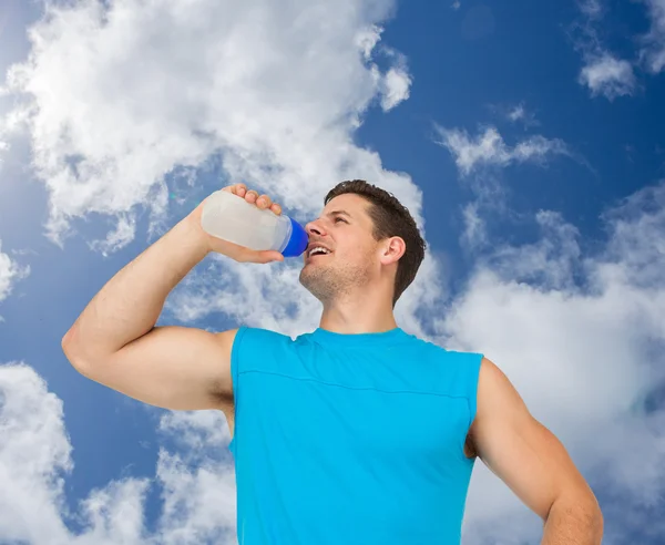 Un jeune homme souriant boit de l'eau — Photo