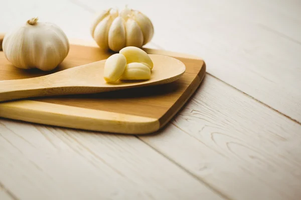 Garlic cloves and bulb on chopping board — Stock Photo, Image