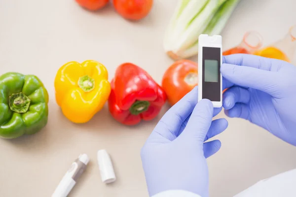 Scientist using device on vegetables — Stock Photo, Image