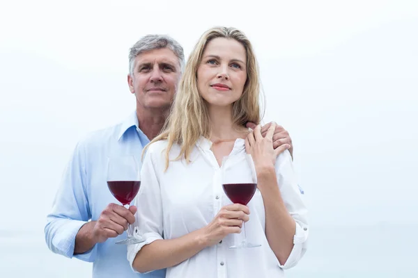 Casal segurando um copo de vinho tinto — Fotografia de Stock