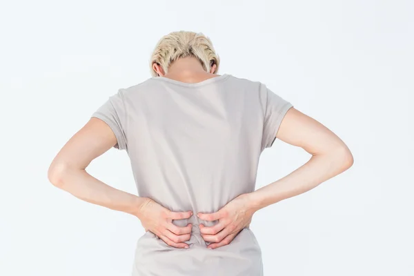 Blonde woman having a back ache and holding her back — Stock Photo, Image