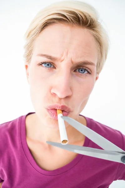 Beautiful blonde cutting a cigarette — Stock Photo, Image