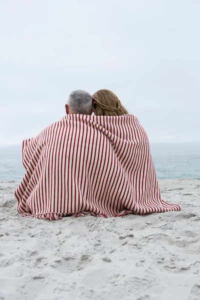 Happy couple sitting at the beach — Stock Photo, Image