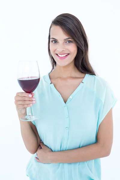 Leende kvinna tittar på kameran med rött vin glas — Stockfoto