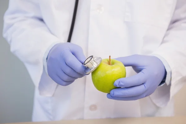 Científico escuchando manzana — Foto de Stock