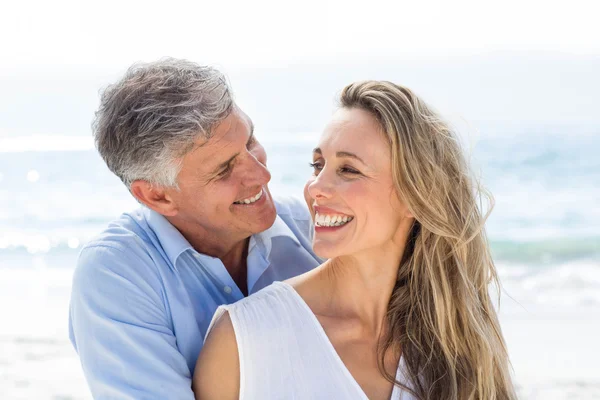 Casal sorrindo um para o outro pelo mar — Fotografia de Stock