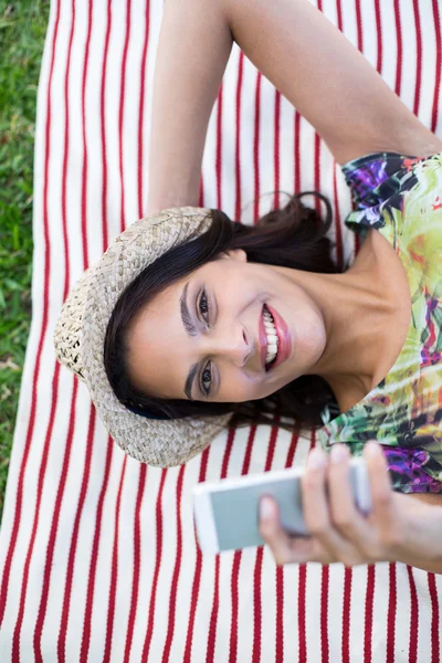 Smiling beautiful brunette lying on the blanket — Stock Photo, Image