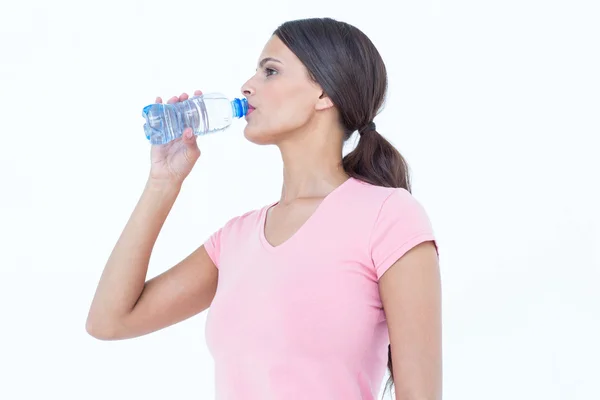 Happy woman drinking bottle of water — Stock Photo, Image