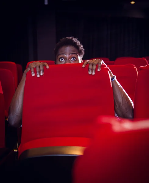 Young man watching a scary film — Stock Photo, Image