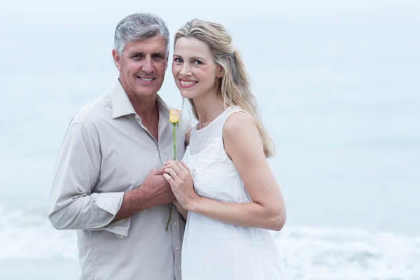 Paar lächelt und hält eine Blume in der Hand — Stockfoto