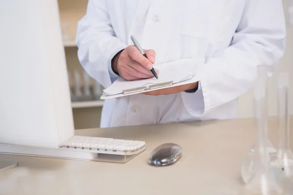 Scientist writing on clipboard — Stock Photo, Image