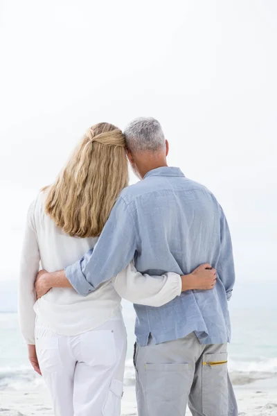 Paar knuffelen elkaar op het strand — Stockfoto