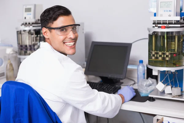Científico sonriente trabajando con computadora —  Fotos de Stock