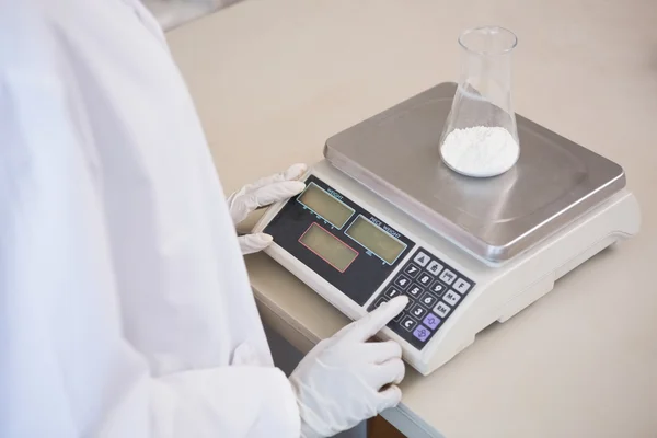 Cientista pesando copo com pó branco — Fotografia de Stock