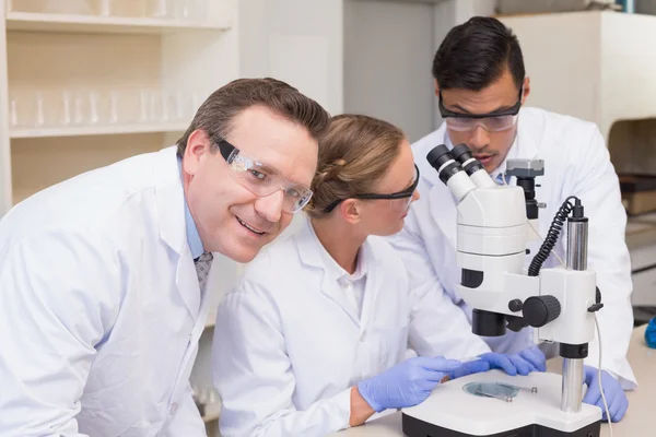 Scientists working together with microscope — Stock Photo, Image