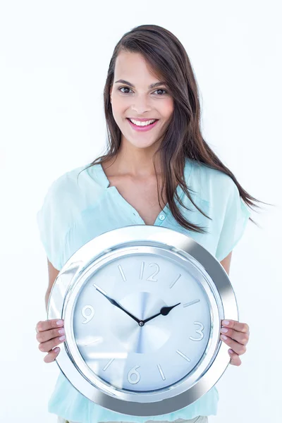 Morena bonita segurando um relógio sorrindo para a câmera — Fotografia de Stock