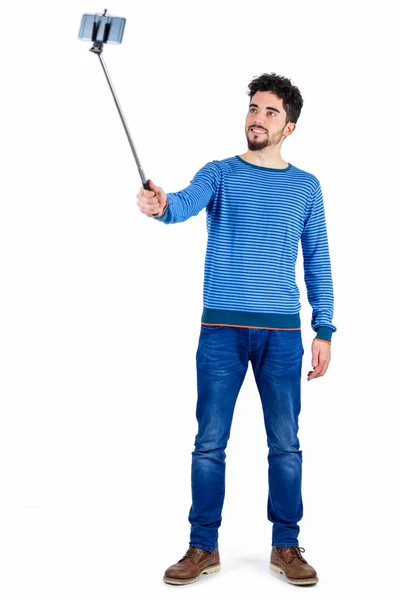 Casual man using a selfie stick — Stock Photo, Image