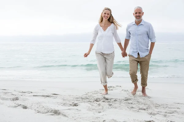 Pareja feliz caminando por el mar — Foto de Stock