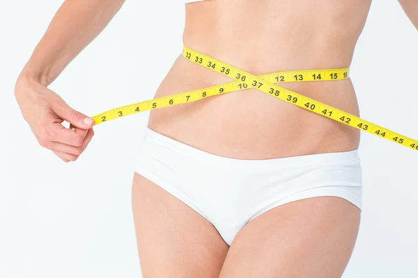 Mulher atraente medindo sua barriga — Fotografia de Stock