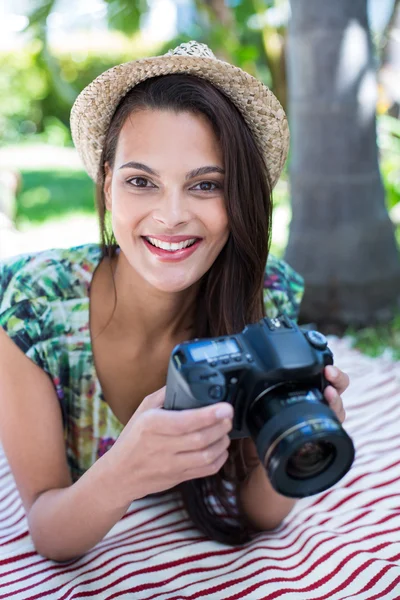 Smiling beautiful brunette lying on the blanket and taking pictu — Stock Photo, Image