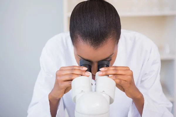 Scientist looking through a microscope — Stock Photo, Image