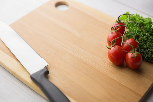 Chopping board tomatoes and parsley — Stock Photo, Image