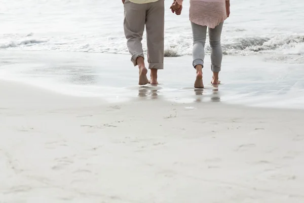 Счастливая пара, идущая вдоль моря — стоковое фото