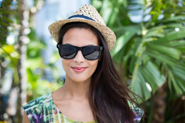 Sonriente hermosa morena con sombrero de paja y gafas de sol —  Fotos de Stock