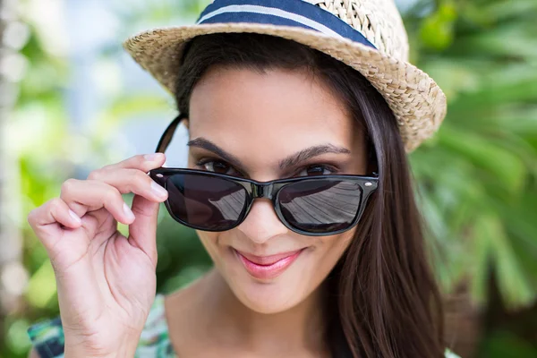 Sorrindo bela morena usando chapéu de palha e óculos de sol — Fotografia de Stock