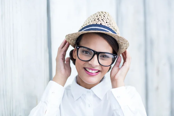 Mooie brunette op zoek naar camera met handen op hoed — Stockfoto