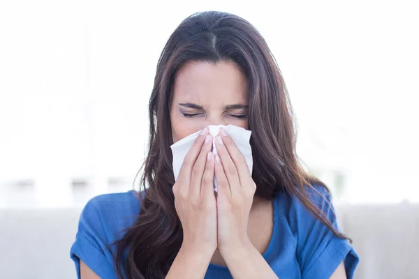 Sick brunette blowing her nose — Stock Photo, Image