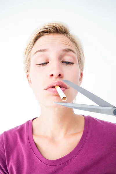 Beautiful blonde cutting a cigarette — Stock Photo, Image